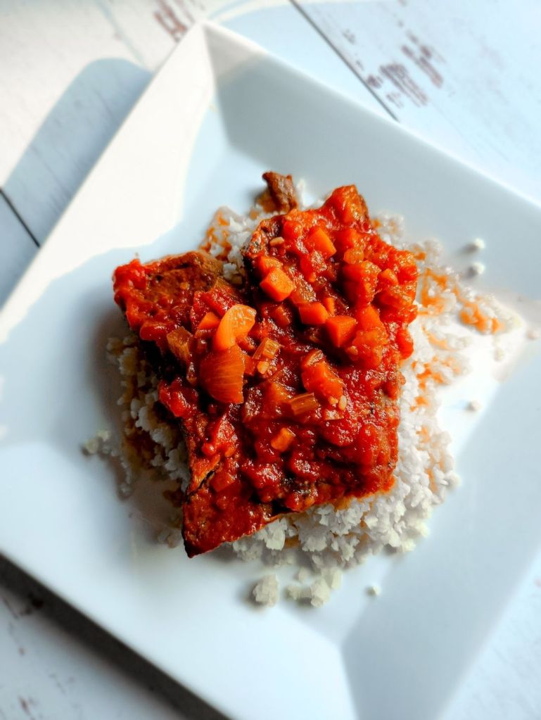 Easy gluten-free copycat McCormick Swiss steak recipe plated on cauliflower rice.