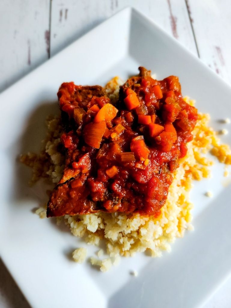 Easy gluten-free copycat McCormick Swiss steak recipe plated on cauliflower rice.