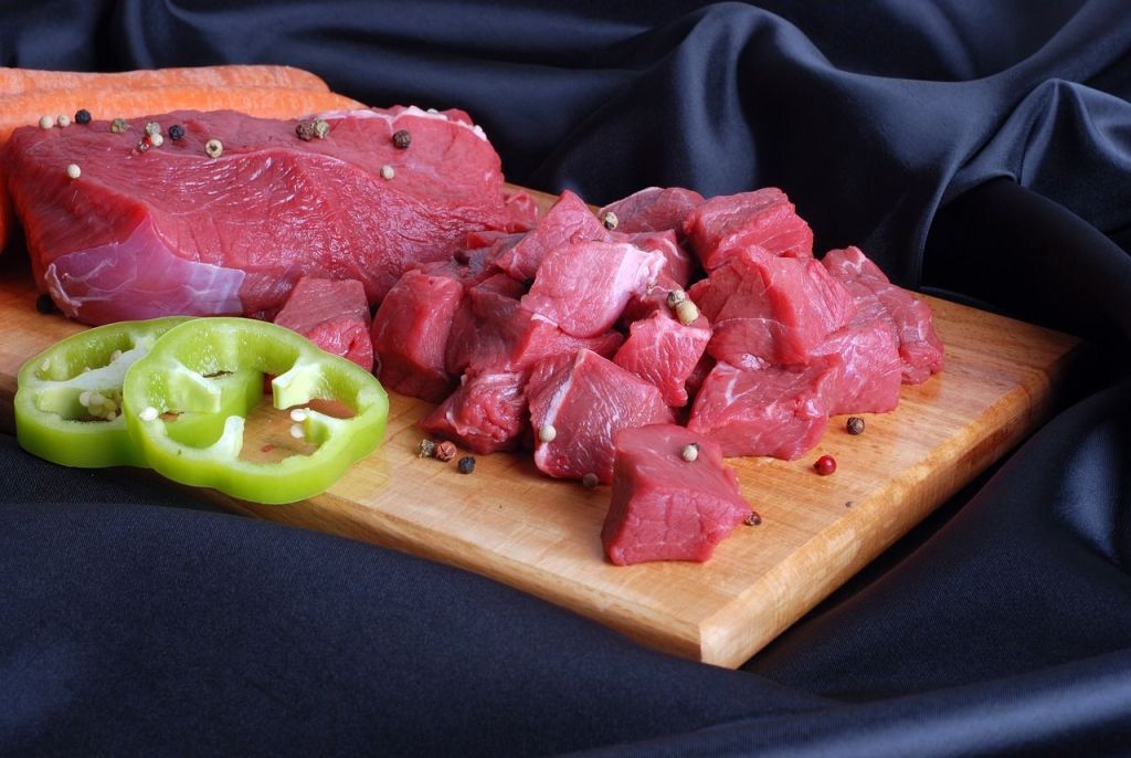Raw round steak on a cutting board.