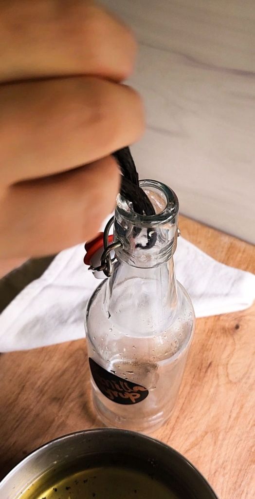 Adding whole vanilla beans to the glass Bottle before adding easy low carb Starbucks Copycat vanilla syrup recipe.