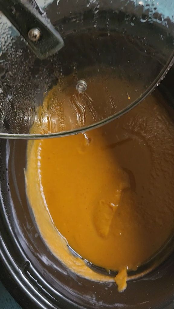 Tilting Crock pot lid so condensation goes back into the pumpkin butter recipe.
