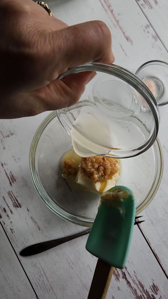 Adding lemon juice to make Lemon garlic butter compound to make gluten-free baked.Almond crusted with lemon garlic halibut.