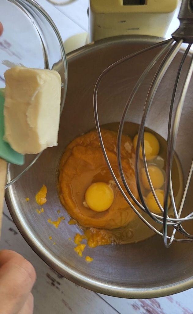 Adding vegan butter to the pumpkin Puree to the mixing bowl to make The best dairy free low carb chocolate cake recipe.