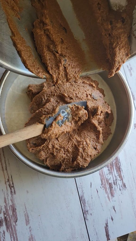 Pouring the batter for The best dairy free low carb chocolate cake recipe into the parchment lined 8 inch round pan.