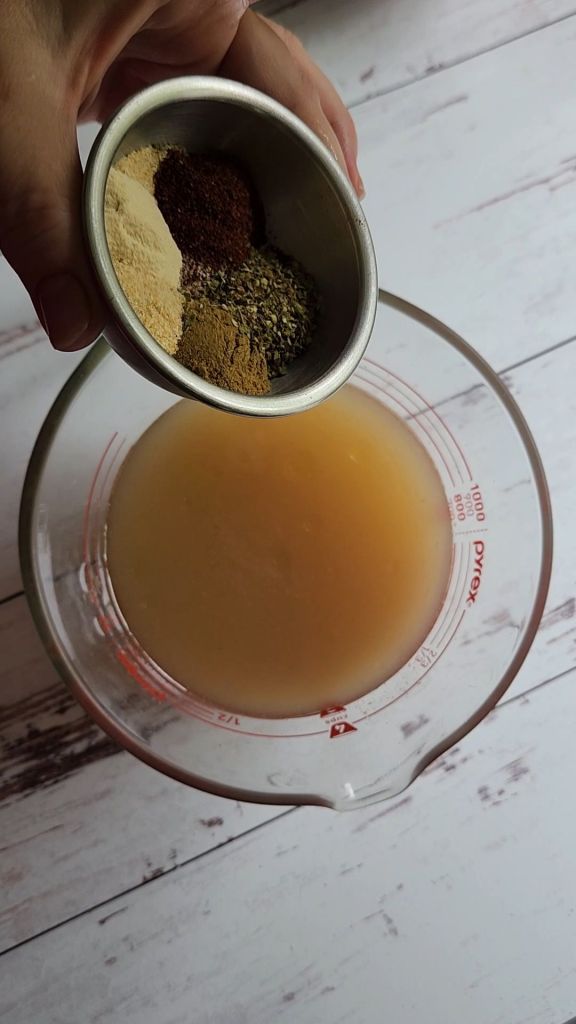 Broth and seasonings forEasy instant pot carnitas from a pork shoulder roast.