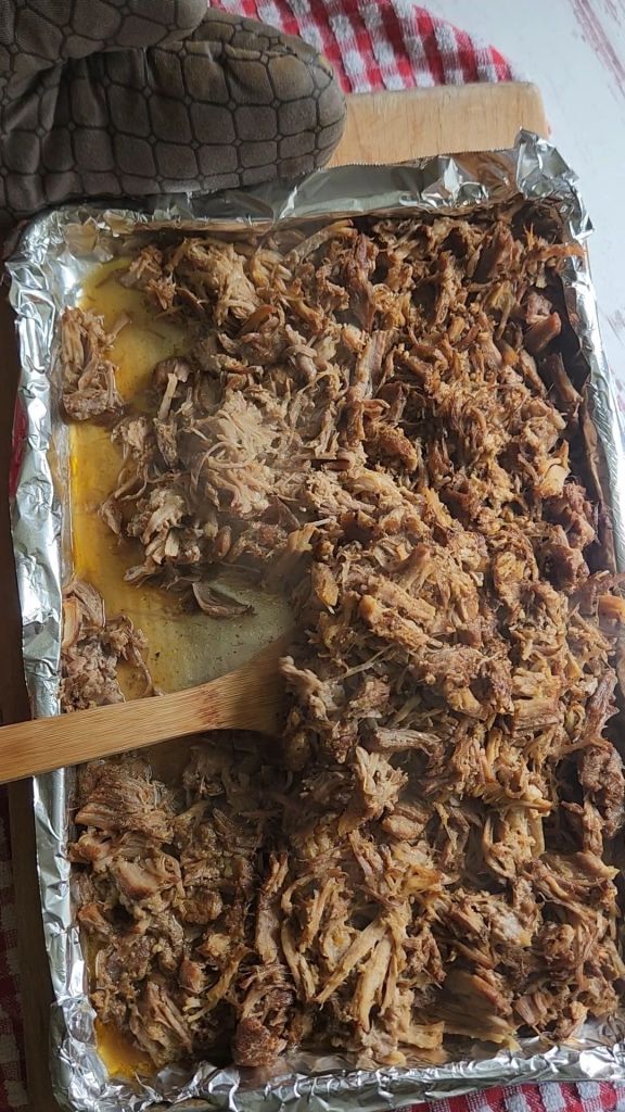 Stirring Shredded pork shoulder meat for Easy instant pot carnitas from a pork shoulder roast.