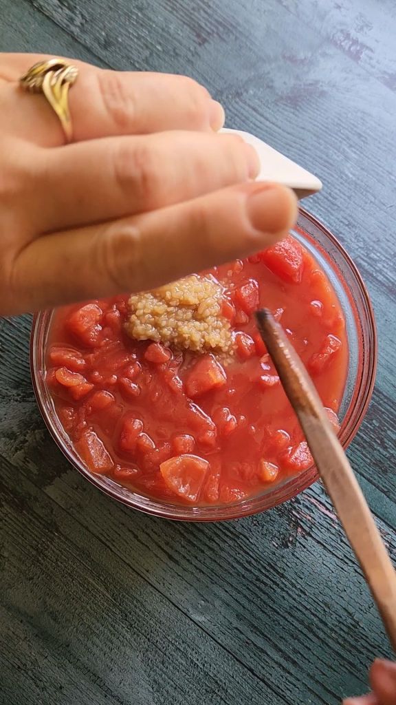 Mixing garlic with dice tomatoes in a large ball