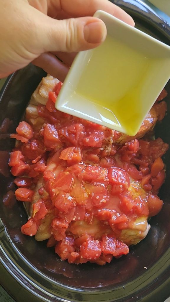 Drizzling olive oil over pork loin roast in slow cooker