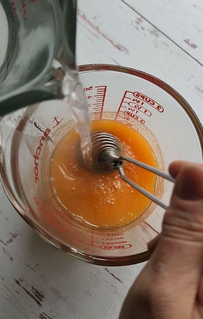 whisking up jel mixture with hot water.