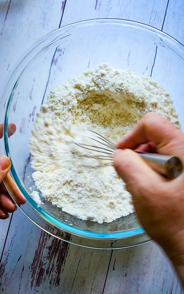 Wisking dry ingredients for Quick Gluten Free Blueberry Muffins with a Cake Mix.