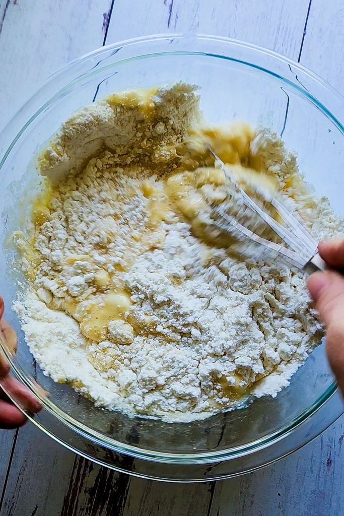 Stirring batter for Quick Gluten Free Blueberry Muffins with a Cake Mix.