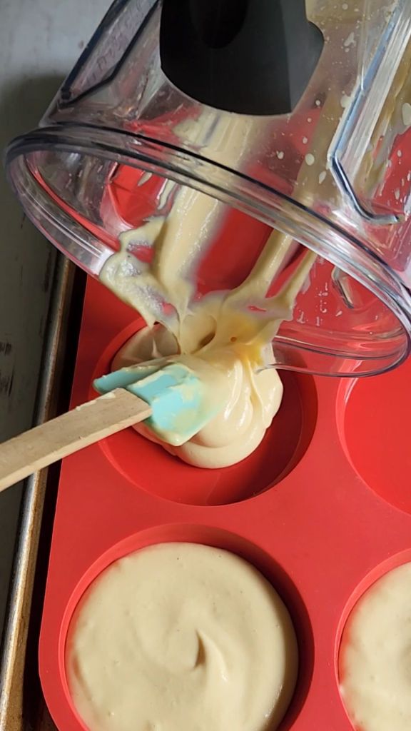 The best ever gluten free soft hamburger buns batter being poured into molds.