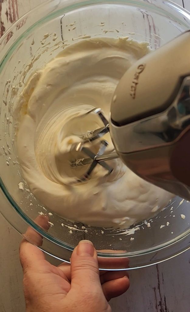 Whipping heavy cream to make 5 ingredient no bake gluten free cheesecake recipe.