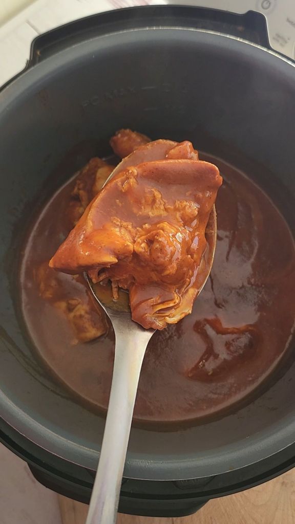 Removing chicken from sauce after cooking.