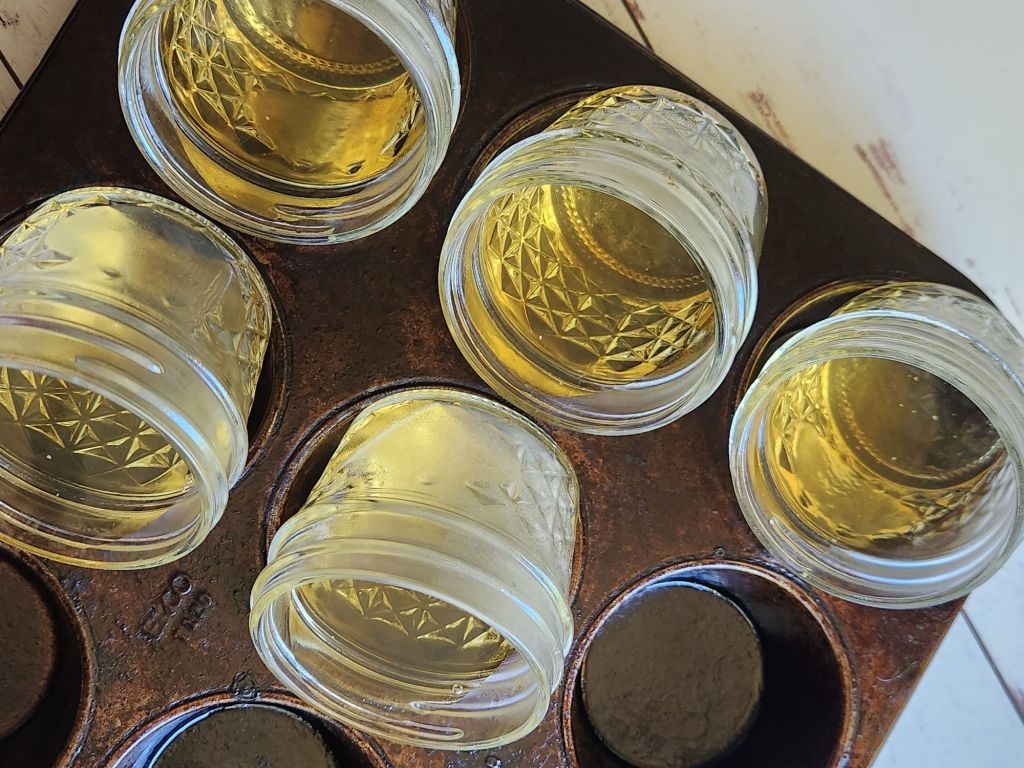 4oz mason jars tilted in muffin pan filled halfway with prepared sugar free jello.