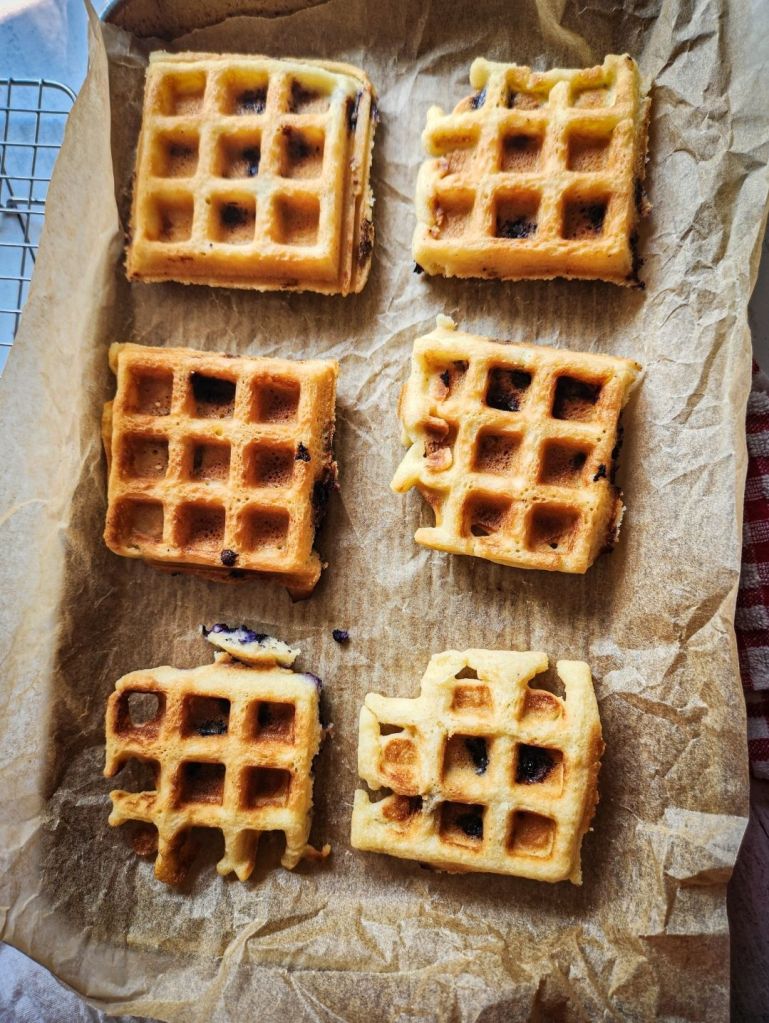 Laying Easy Gluten-Free Dairy-Free Blueberry Waffles on a baking sheet to freeze.