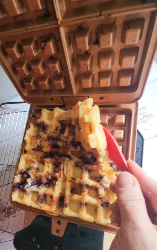 Laying Easy Gluten-Free Dairy-Free Blueberry Waffles on a baking sheet to freeze.