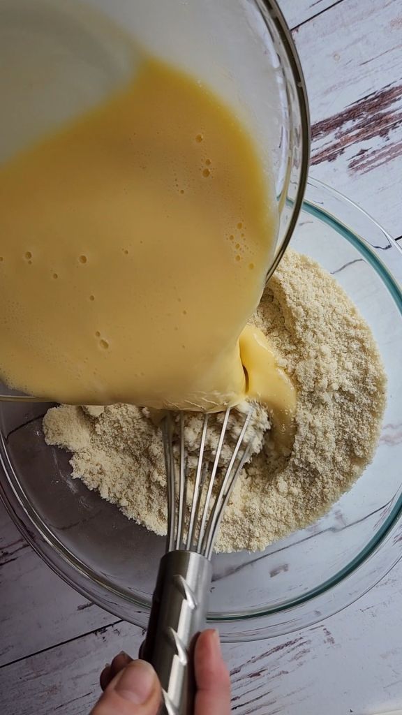 Mixing wet ingredients into dry ingredients for Easy Gluten-Free Dairy-Free Blueberry Waffles Recipe.