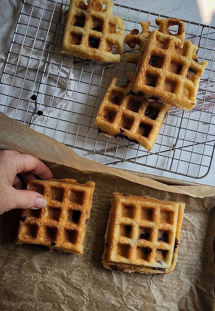 Placing Easy Gluten-Free Dairy-Free Blueberry Waffles on a baking sheet to freeze.