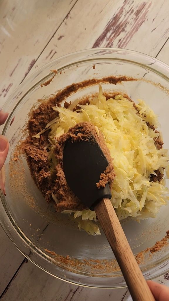 Folding shredded yellow squash into batter for Easy gluten free zucchini bread with yellow squash recipe.