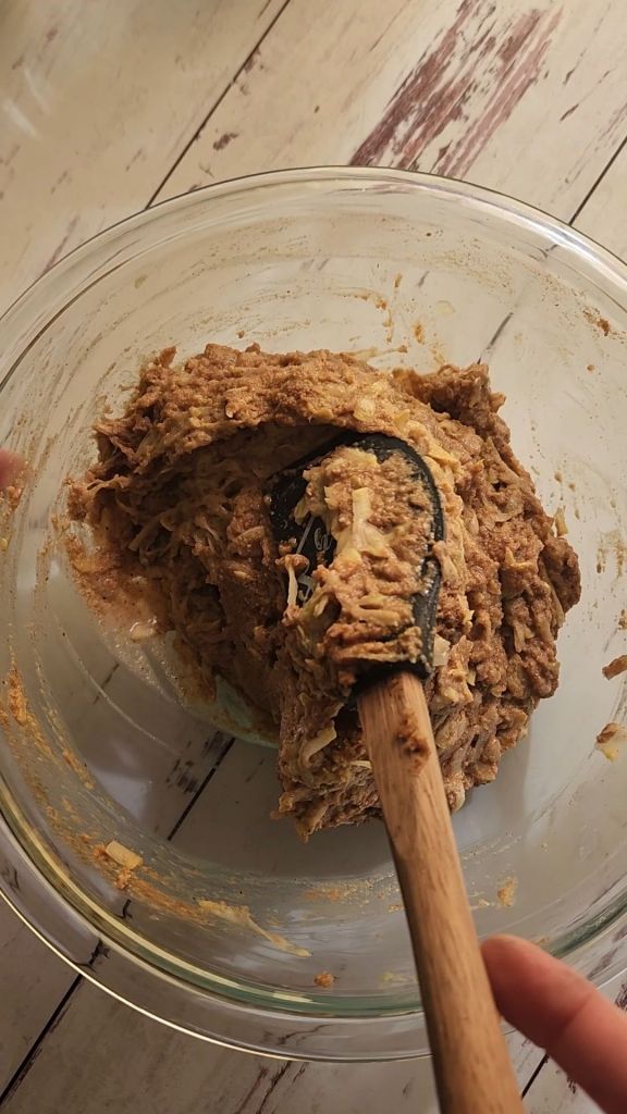 Folding shredded yellow squash into batter for Easy gluten free zucchini bread with yellow squash recipe.