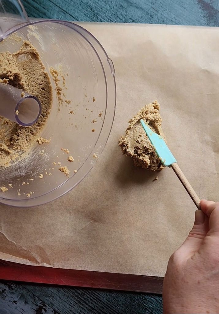 Placing dough for Gluten-Free Nut Free Sunflower Seed Crackers Recipe dough onto parchment paper lined baking sheet.