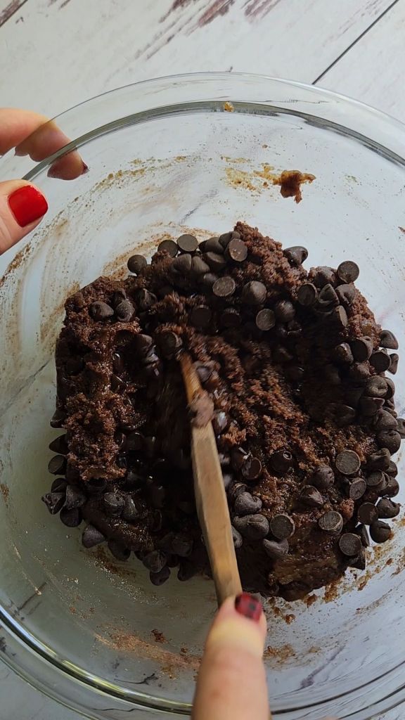Stirring chocolate chips into Dough for Gluten free keto almond butter protein cookies recipe.