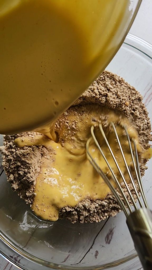 Adding wet ingredients to dry ingredients for Gluten free low carb pumpkin pecan crunch coffee cake.