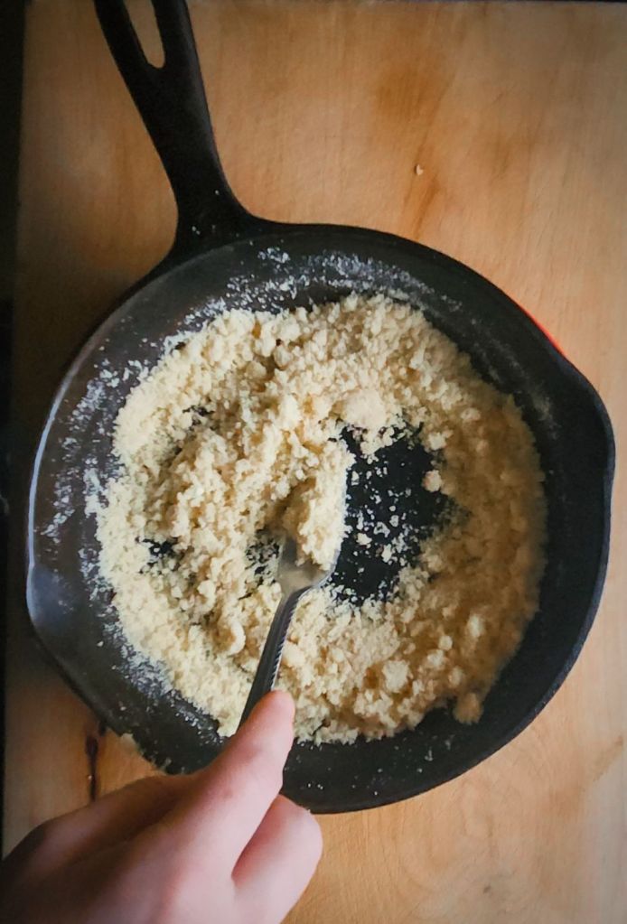 StirringCrumbs into melted butter into cast.Iron skillet.