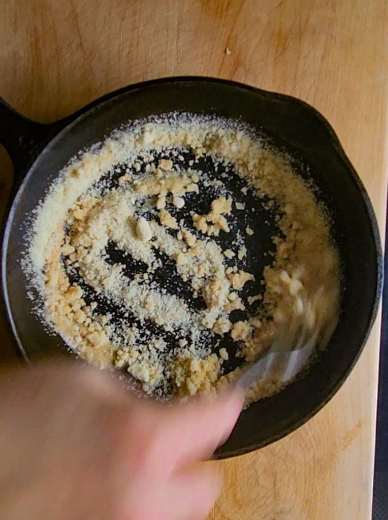 StirringCrumbs into melted butter into cast.Iron skillet.