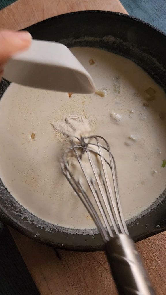Whisking xanthan gum into cream sauce.