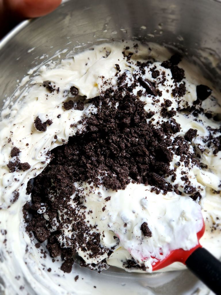 Folding chocolate sandwich cookies into no bake cheesecake batter