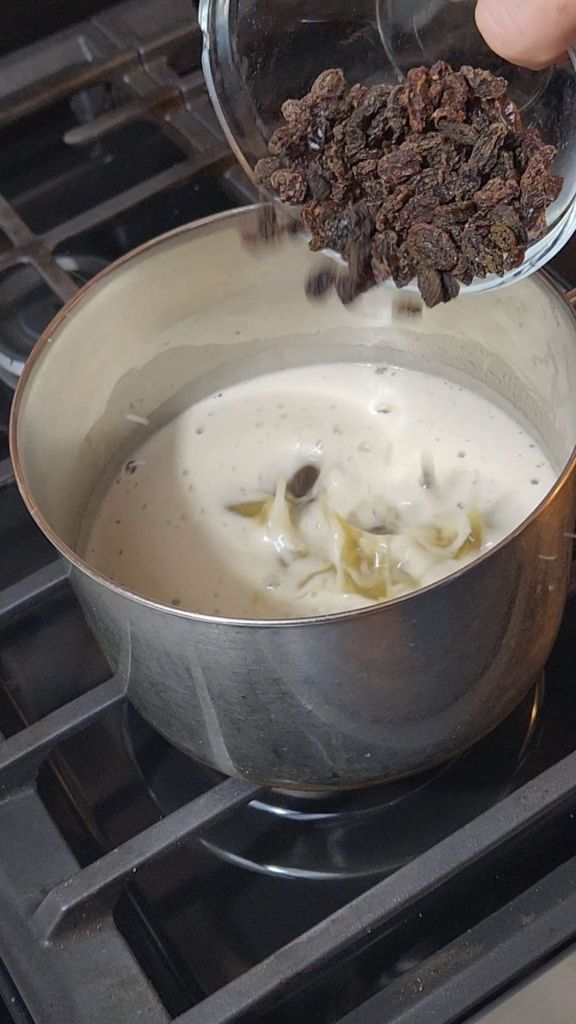 Pouring raisins into melted butter and sugar mixture